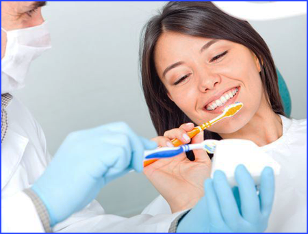 Picture of dentist teaching patient how to brush teeth properly.